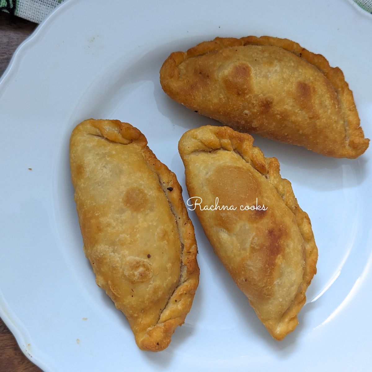 3 gujiyas in a white plate