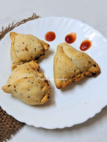 3 air fried samosas placed on a white plate.