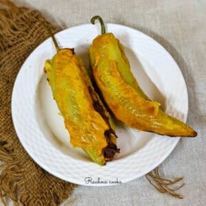 Mirchi bajji on a white plate and a brown mat