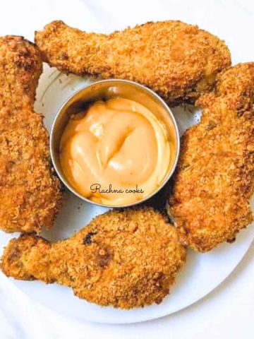 4 fried chicken drumsticks with dip in the center