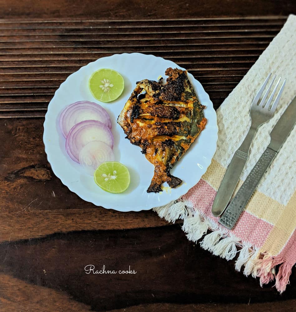 Pomfret tawa fry served with lemon and onion slices