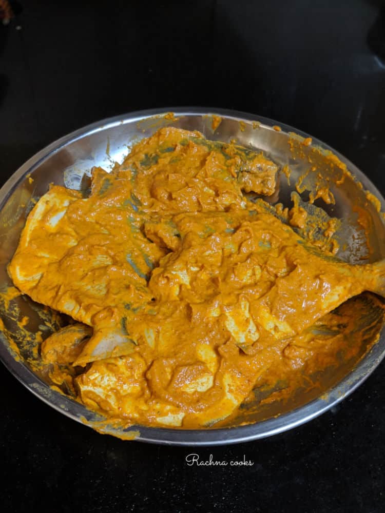 Pomfret fish marinated in masala on a shallow plate.