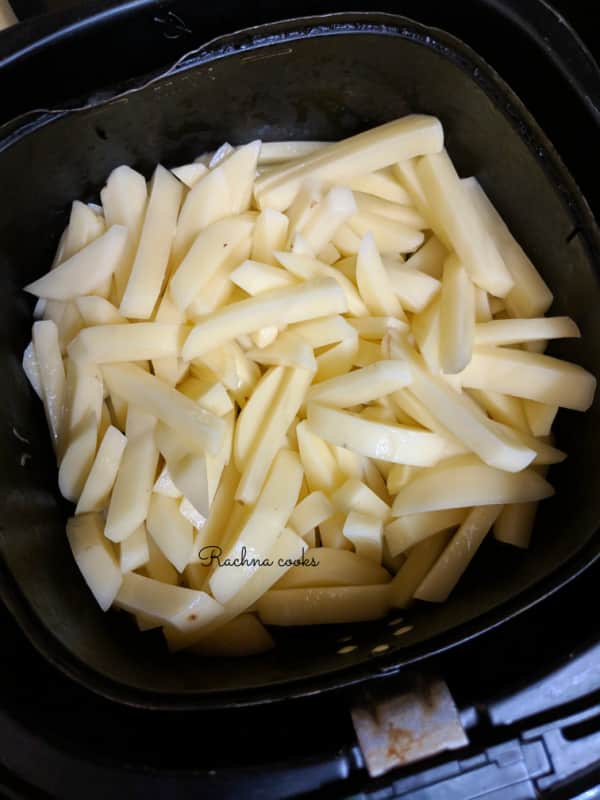 Fries placed in air fryer ready for air frying.