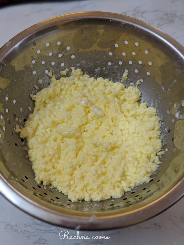 Butter after it is separated from whey in a colander.