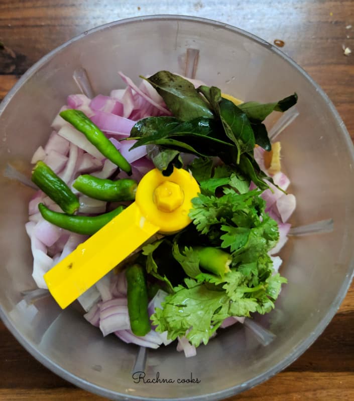 onions, green chillies, curry leaves, cilantro leaves, ginger in a vegetable chopper.