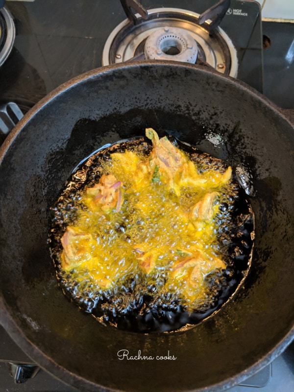 onion pakodas frying in a kadhai
