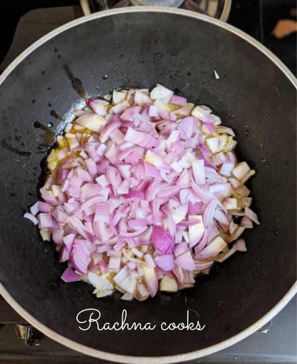 Chopped onions being fried in a pan.