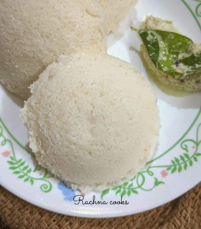 2 idlis on a white plate with chutney.