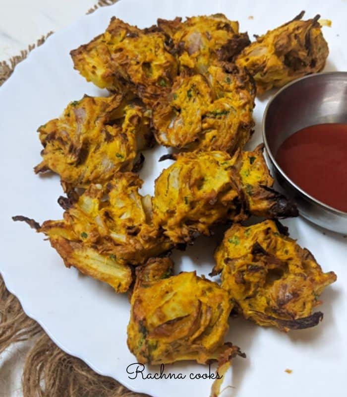 air fryer onion pakoda on a plate served with ketchup