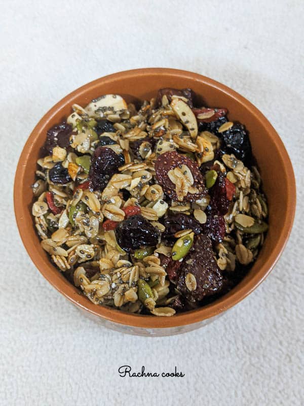 tasty granola with berries and oats in a brown round bowl on a white background