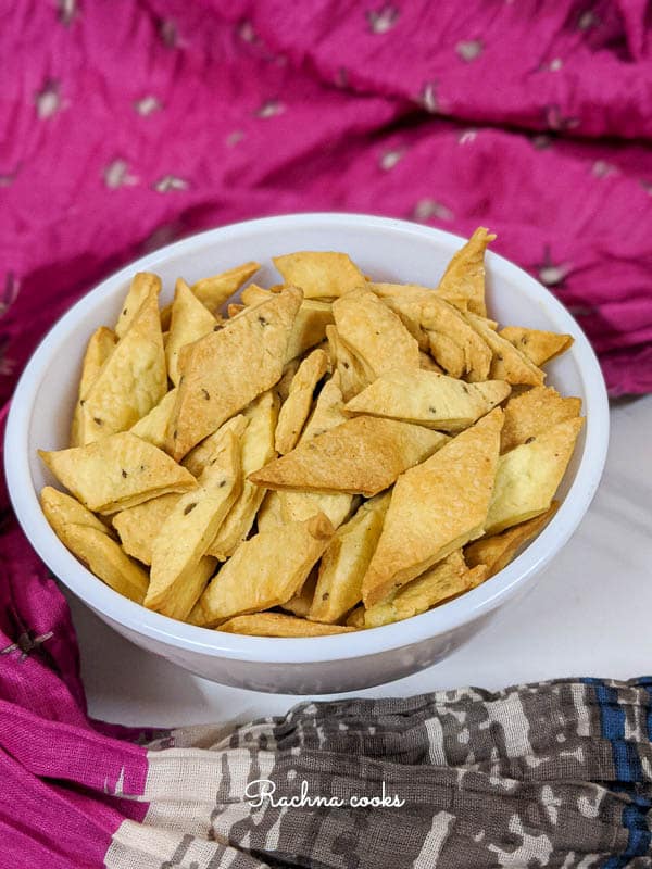 air fryer namak pare in a white bowl with a colourful background.