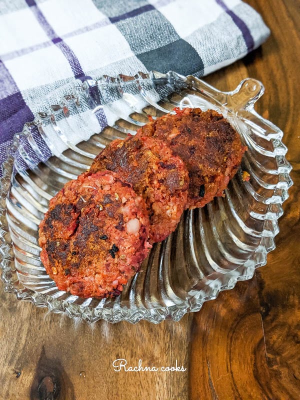 red beetroot tikki on a transparent platter with a brown background.