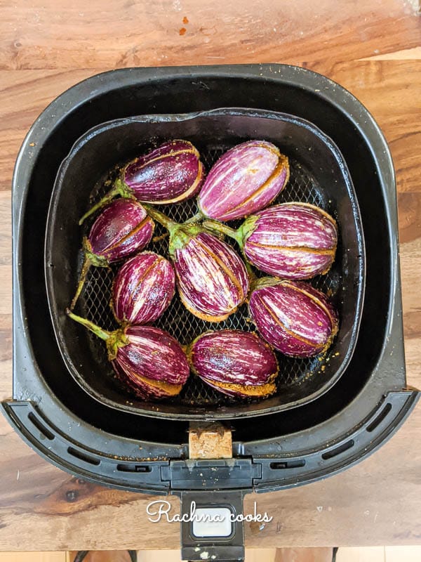 Stuffed aubergines kept for air frying in a air fryer basket