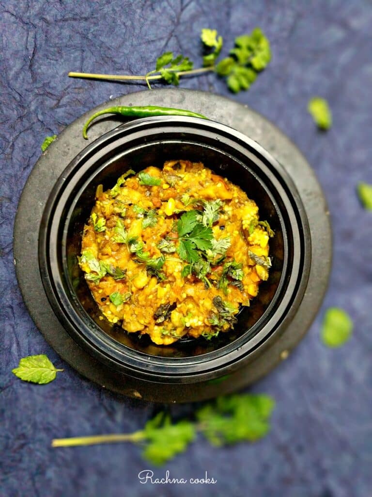 eggplant mash in a black bowl with purple background