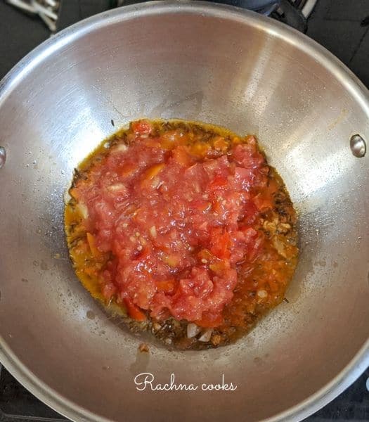 Tomato puree added to the wok