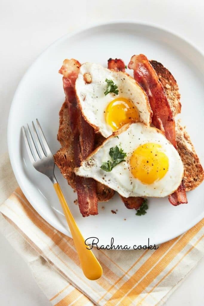 sunny side up eggs with bacon and toast on a white plate