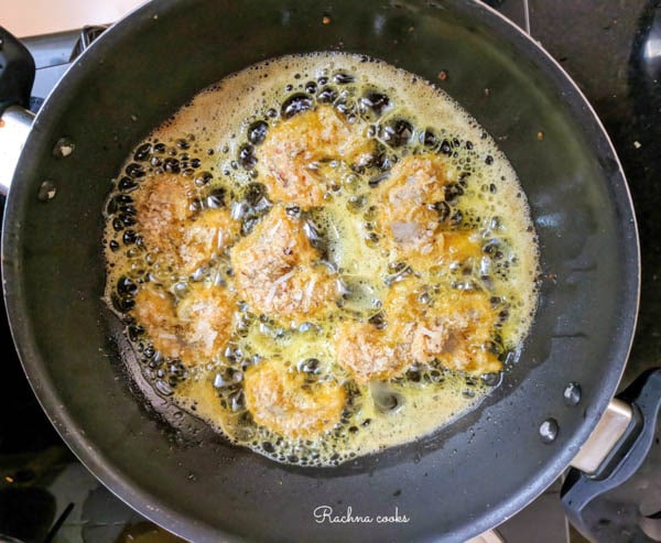 coconut prawns being pan fried.