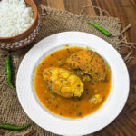 Bengali fish curry with fish fillets in a white plate