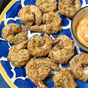 Coconut shrimp after air frying on a blue patterned plate.