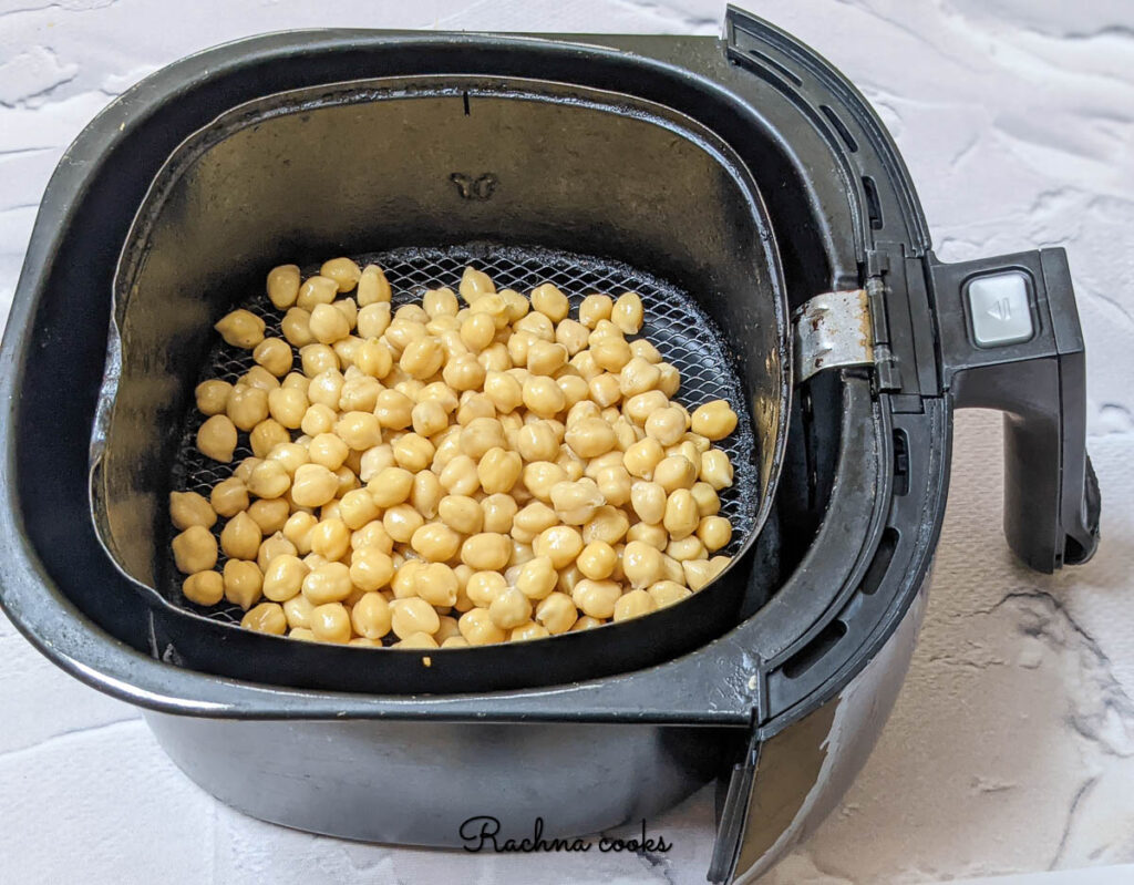 chickpeas spread in air fryer basket for air frying