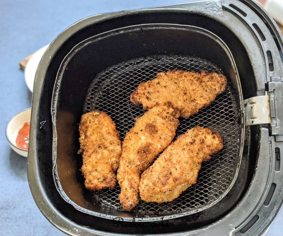 Golden crispy air fried chicken tenders in air fryer basket