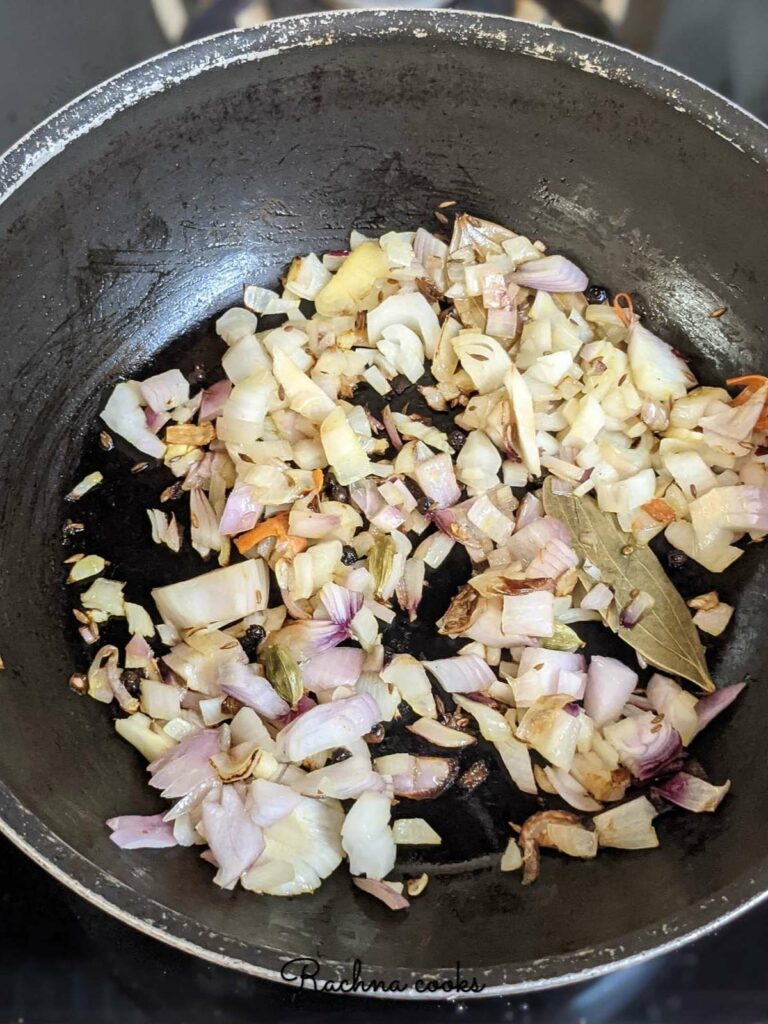 Frying onions and whole garam masala in a pan