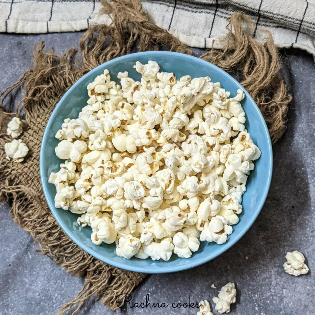 Popcorn in a blue bowl against a brown mat.