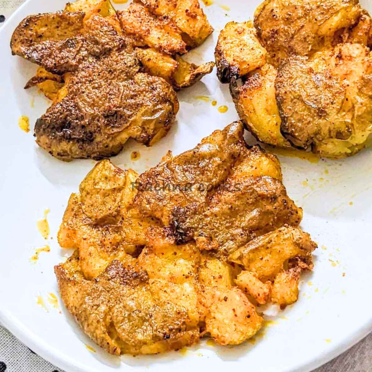 3 smashed potatoes served on a white plate