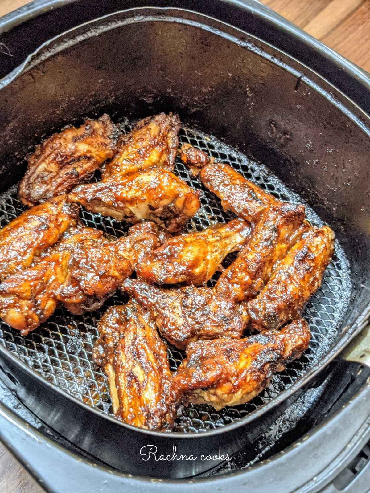 frozen bbq chicken wings air fried in the air fryer basket.