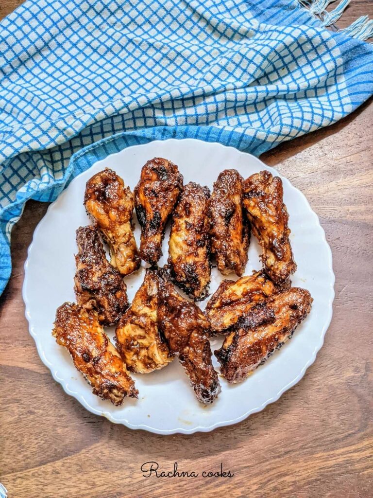delicious frozen bbq chicken wings done in air fryer on a white plate with a blue checked napkin in the background.