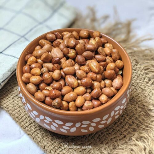 a bowl of roasted peanuts in air fryer with a spicy coating.