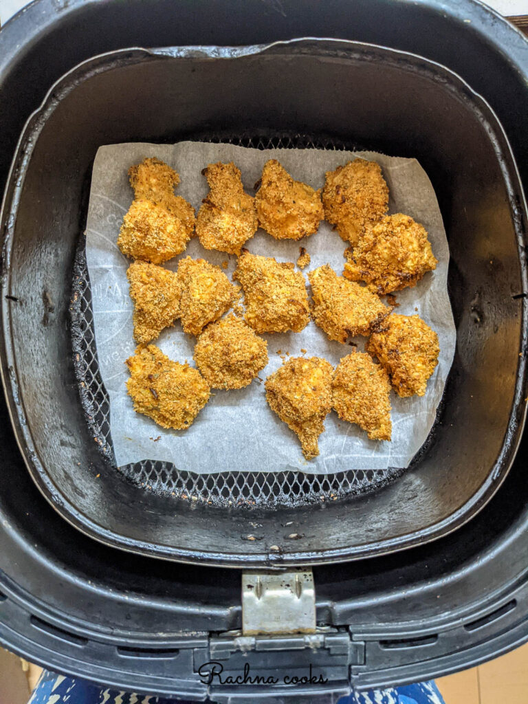 air fryer breaded mushrooms fried in air fryer basket.