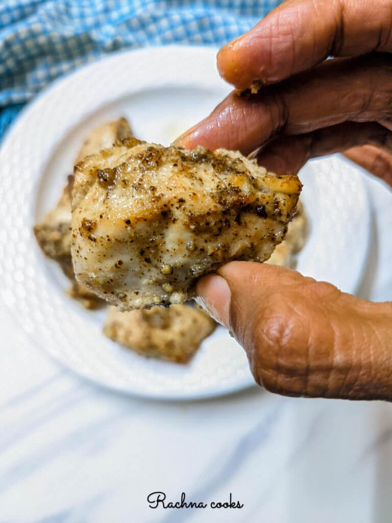 Close up of a crispy lemon pepper chicken piece after air frying.