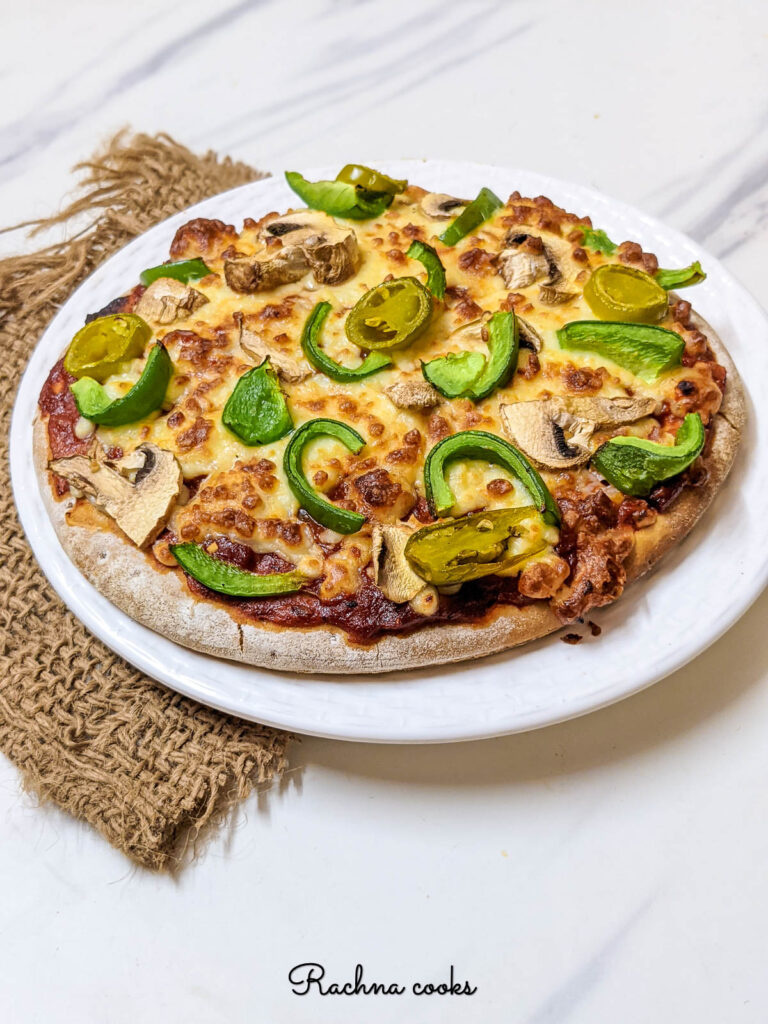 Delicious pizza in air fryer on a white plate.