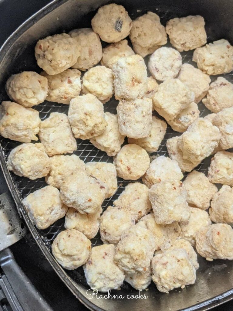 Frozen tater tots in air fryer basket ready for air frying.