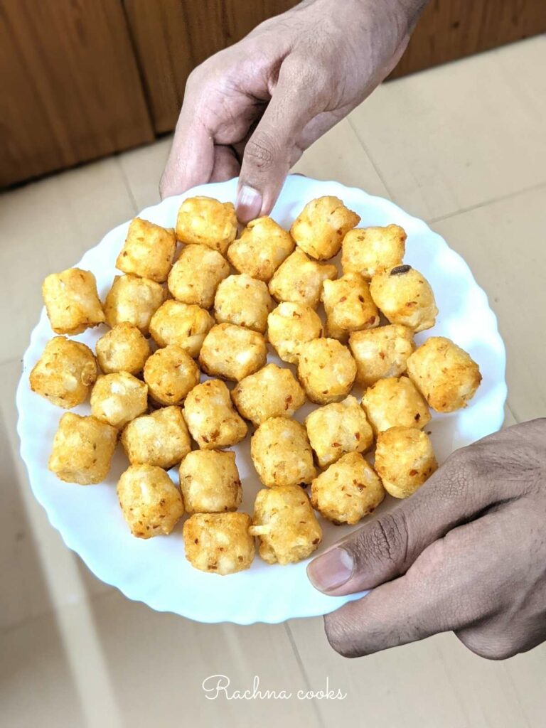 Tasty golden tater tots on a white plate.