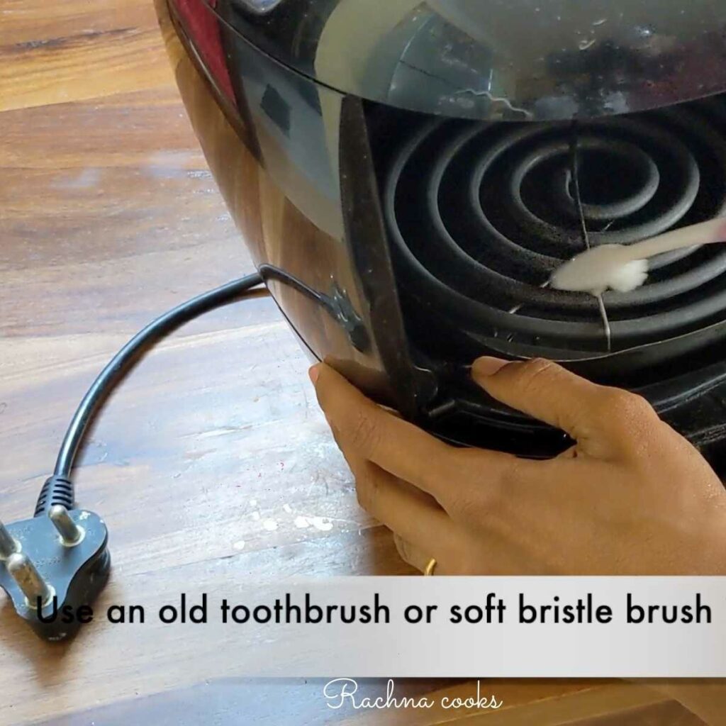 Use toothbrush to clean caked grease from air fryer heating coil.