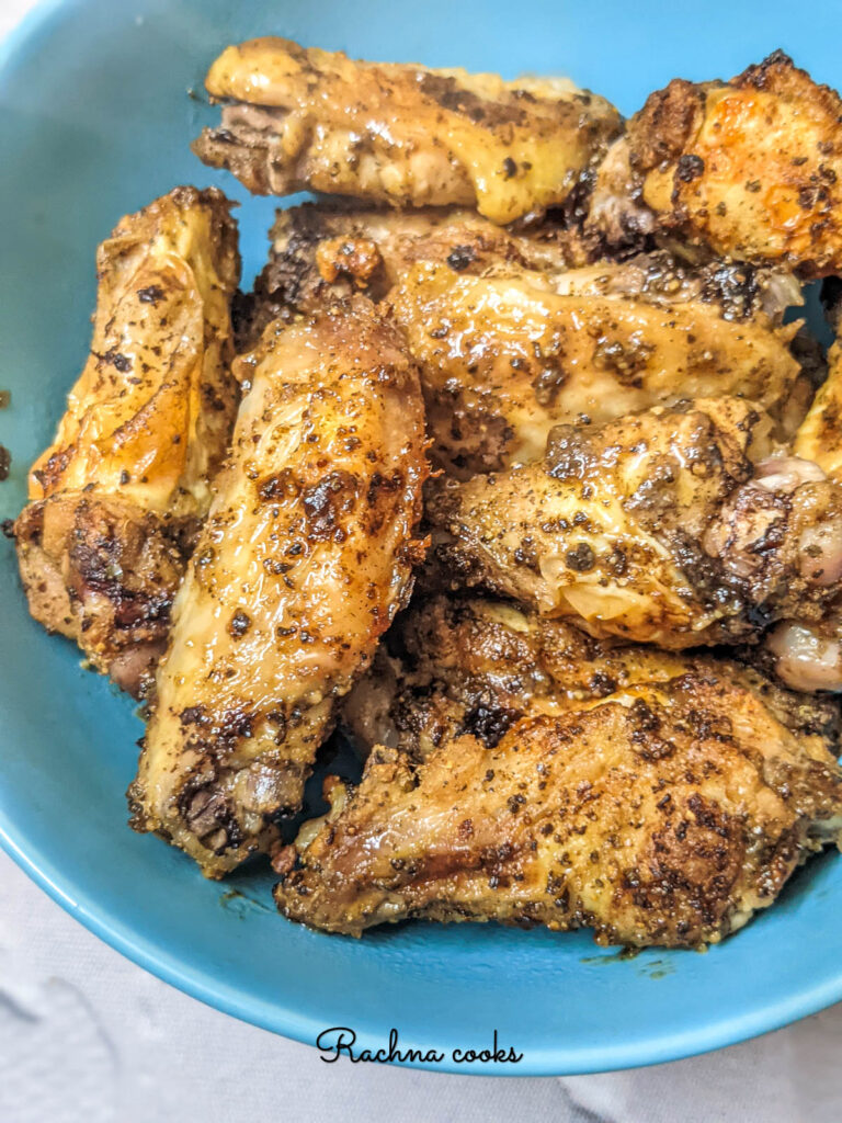 Close up of air fryer lemon pepper chicken wings in a blue bowl.