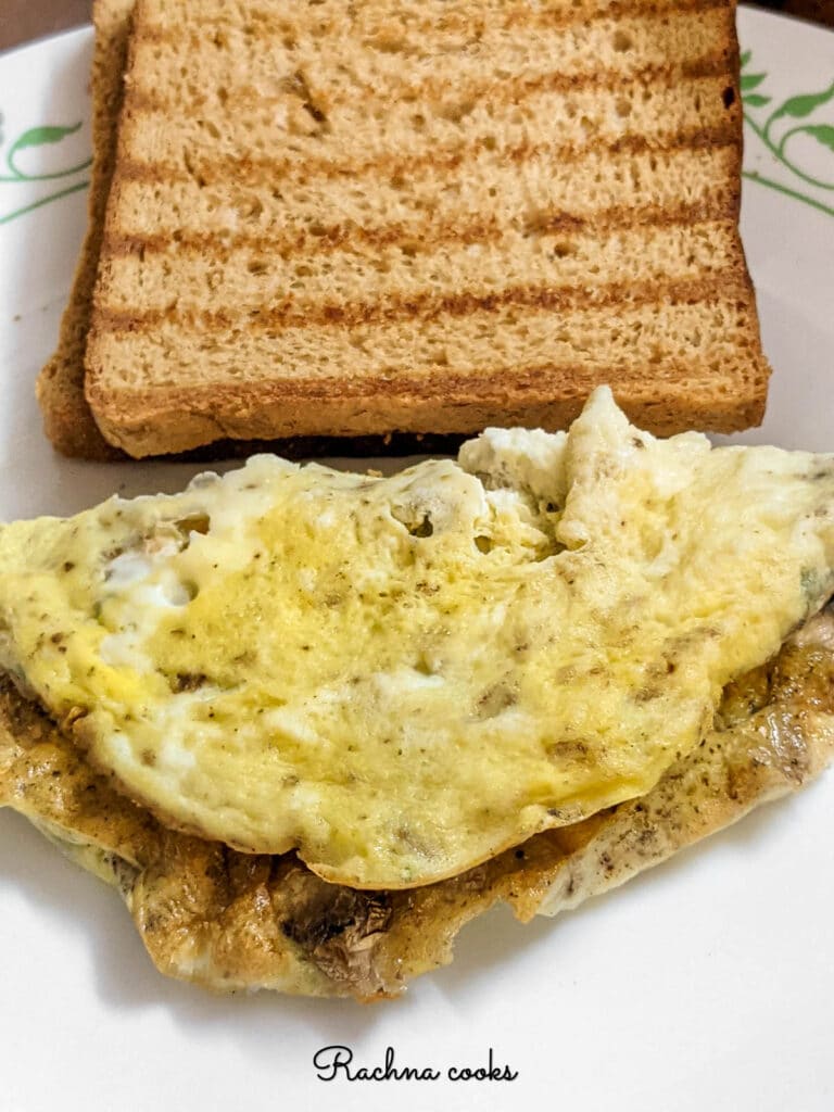 omelette on the plate with toasted bread slice.