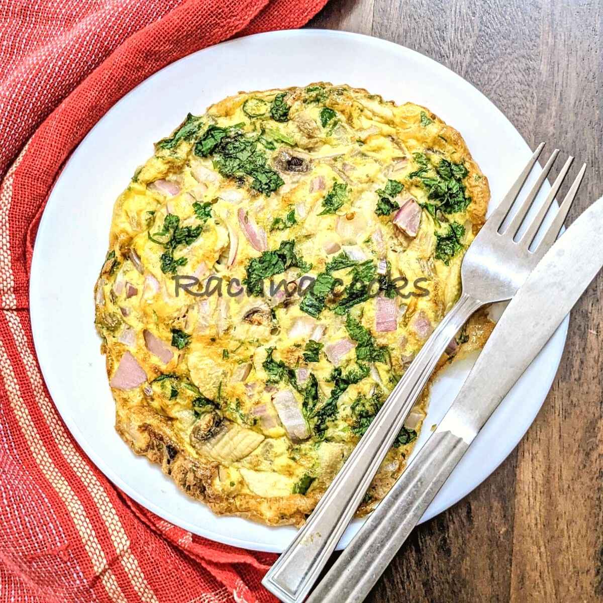 Top shot of air fried omelet on a white plate with fork and knife.