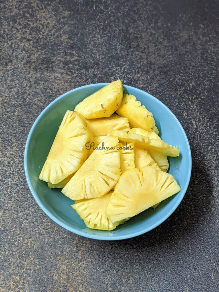 Pineapple slices cut in halves in a blue bowl