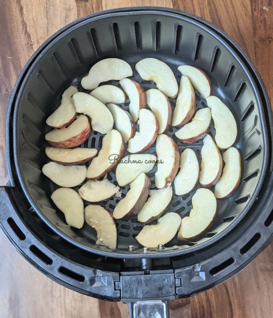 apple slices brushed with butter or oil placed in one layer in air fryer basket