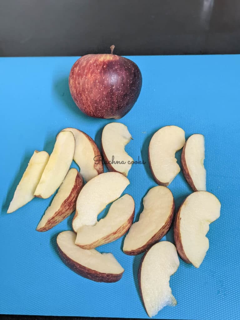 apple slices on a blue board with a whole apple visible