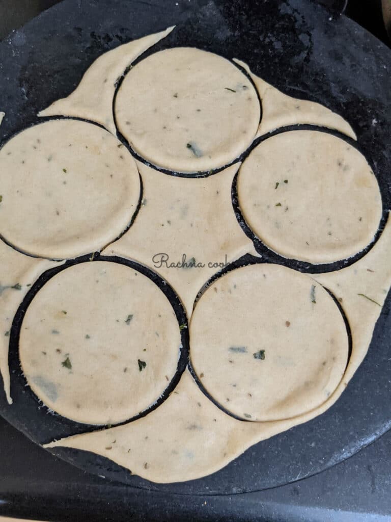 Rolled out dough with round shapes of mathri cut out