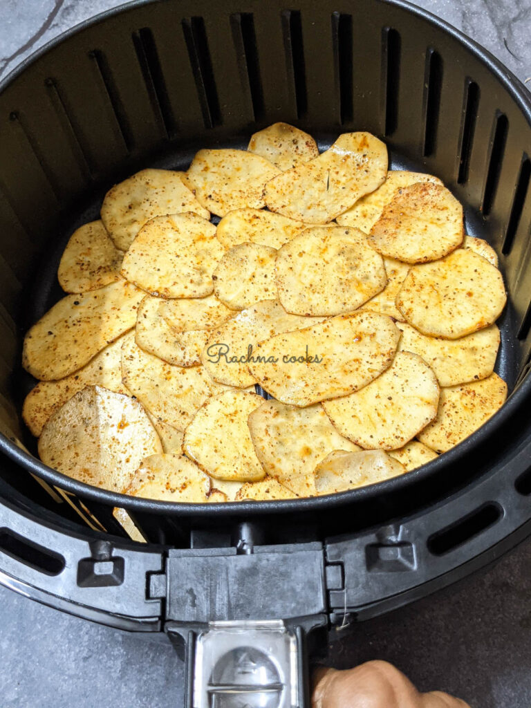 Sweet potato chips laid in air fryer basket ready for air frying.