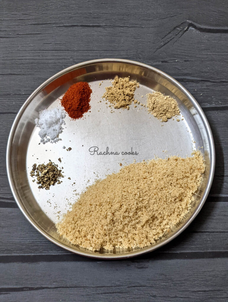 Breadcrumbs, onion powder, garlic powder, cayenne, pepper and salt on a shallow plate