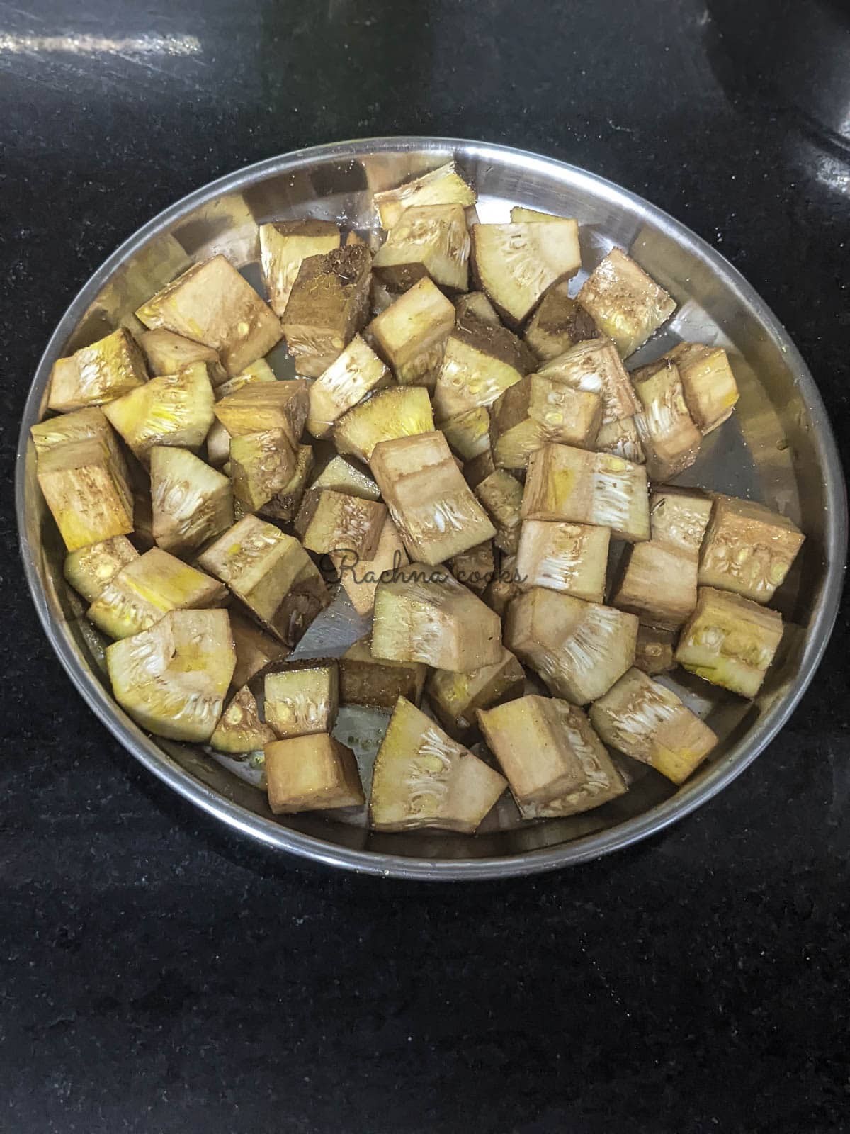 Raw jackfruit pieces with sprinkled salt and 2 tsp. oil on a steel plate.