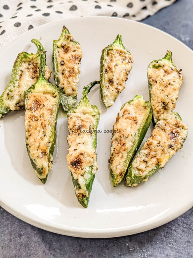 Golden air fried jalapeno poppers on a white plate