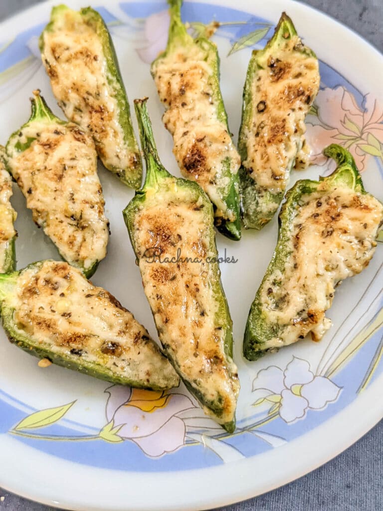 8 Golden air fried jalapeno poppers on a white plate with a floral design