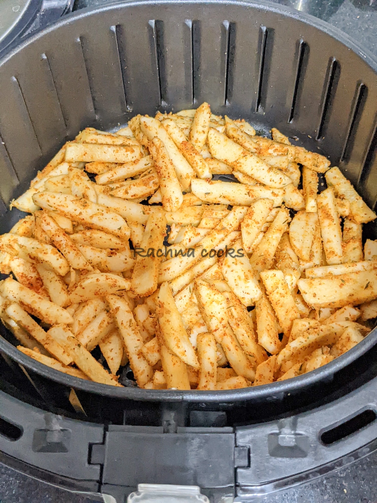 Seasoned turnip fries in an air fryer basket ready for air frying.